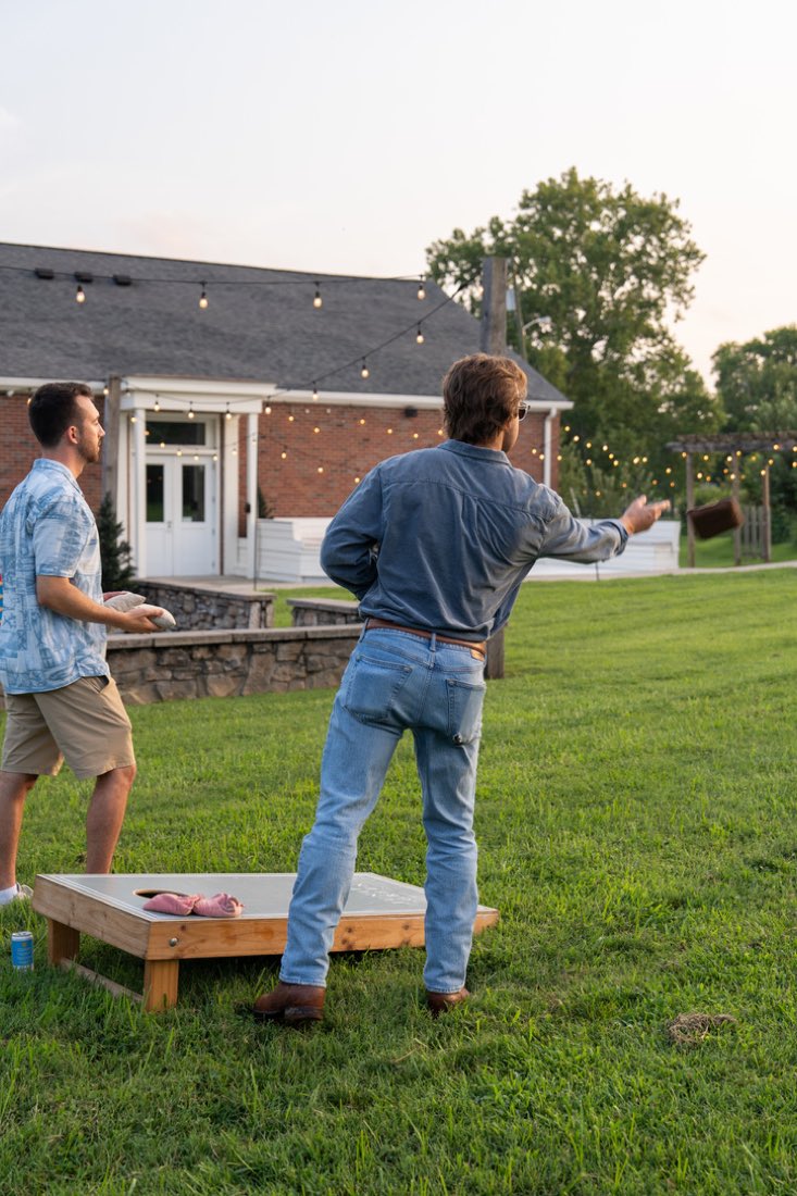 Cornhole on the lawn at sunset